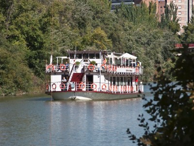 a boat traveling along a river next to a body of water
