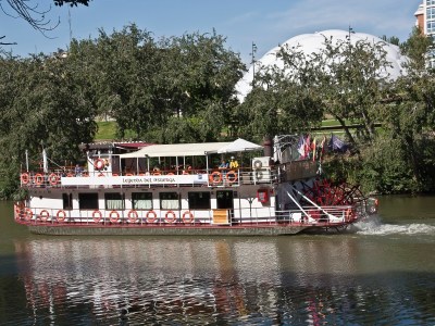 a boat traveling along a river next to a body of water