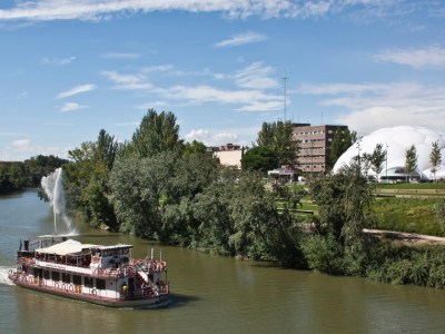 a boat traveling along a river next to a body of water