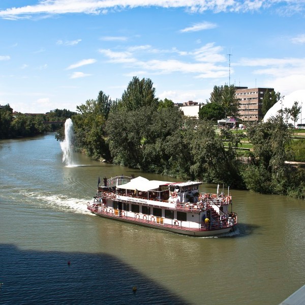 a boat floating along a river next to a body of water