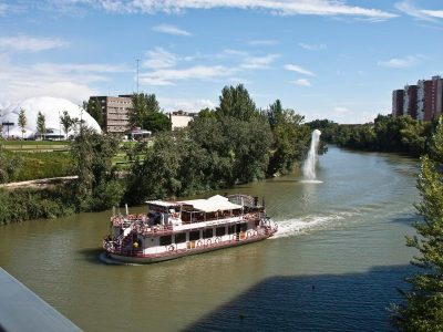 a boat traveling along a river next to a body of water