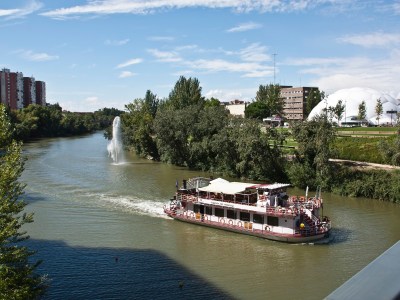 a boat traveling along a river next to a body of water