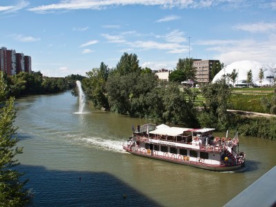 a boat traveling along a river next to a body of water