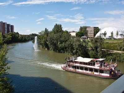 a boat traveling along a river next to a body of water