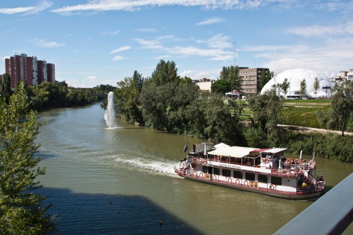 a boat traveling along a river next to a body of water