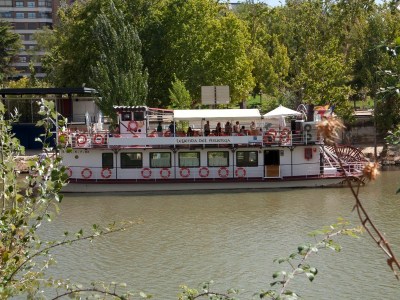 a boat floating along a river next to a body of water