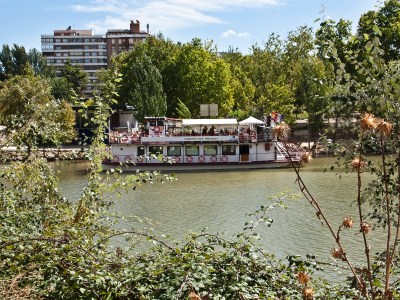 a group of people standing next to a body of water surrounded by trees