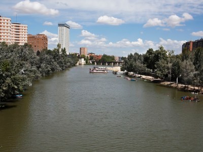 a small boat in a body of water with a city in the background