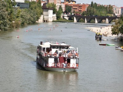 a small boat in a body of water with a city in the background
