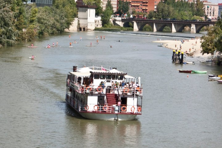 a small boat in a body of water with a city in the background