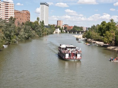 a small boat in a body of water with a city in the background