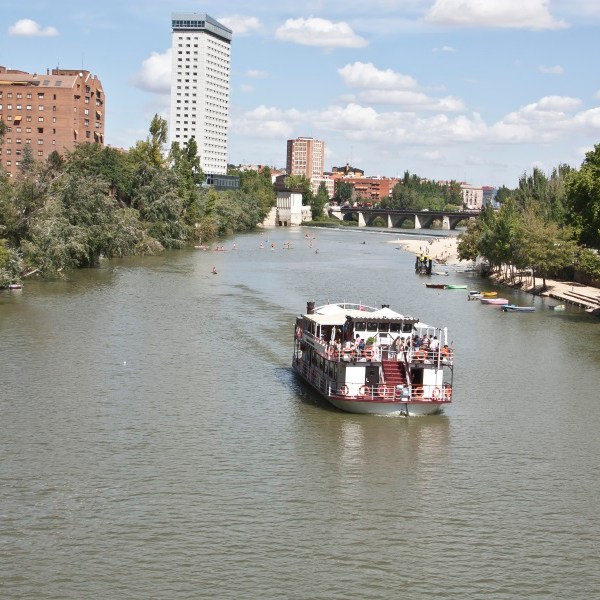 a small boat in a body of water with a city in the background