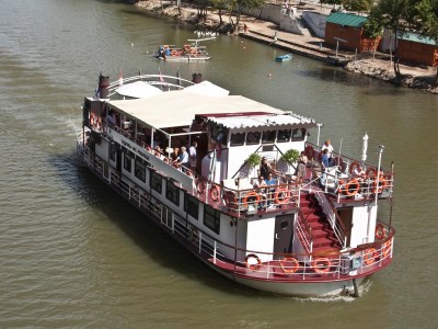 a boat floating along a river next to a body of water