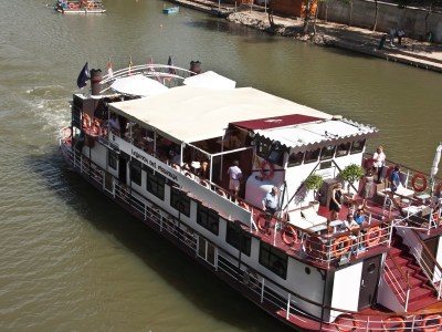 a boat floating along a river next to a body of water